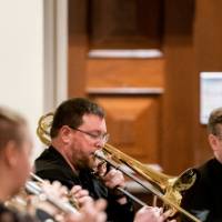 The band plays, trumpets and tuba